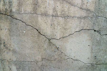 Cracked concrete slab. Wall made of cement with a crack. House foundation repair. Texture surface or...