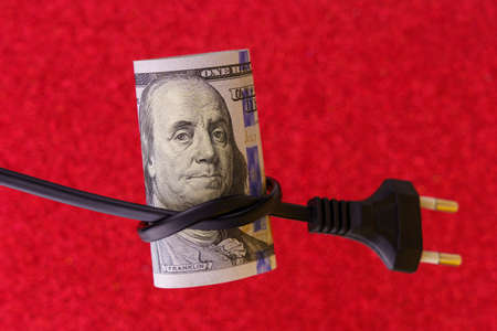 Knotted electric cord around the neck of the president of the dollar bill, selective focus. The concept of the energy crisis and electricity inflation. Rising electricity prices. Copy space.の写真素材