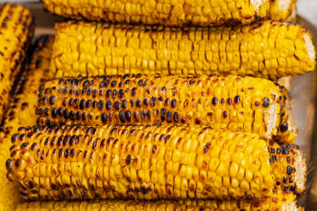 Close up of grilled corn for sale at the international street food festival, selective focus. Background. Traditional festive cuisineの写真素材