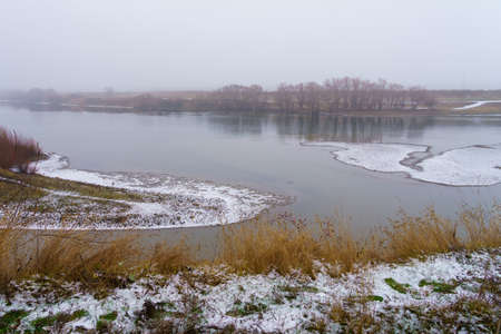 Foggy bank of a river or reservoir in damp cold weather. Background with copy space for textの写真素材