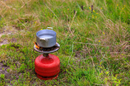 Pot on a gas burner in field conditions. Background with copy space for textの写真素材