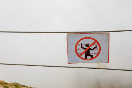 Warning signs about danger against the background of fog mountain cliffs, selective focus....