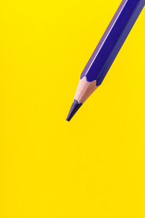 Colored pencil close-up with selective focus on the stylus and a blurred yellow background. Copy space for text.の写真素材