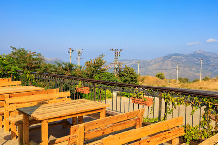 Wooden tables on the terrace of a restaurant in the mountains with a beautiful view. Popular places among tourists. Southern coastal Taurus Mountains in Turkeyの写真素材