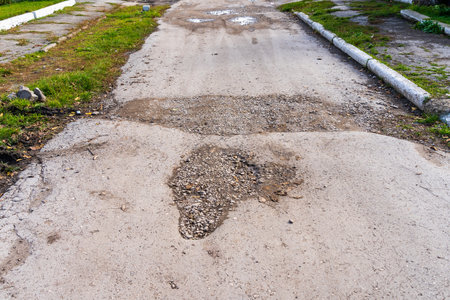The road is in disrepair with potholes. Background with selective focus as copy space for textの写真素材