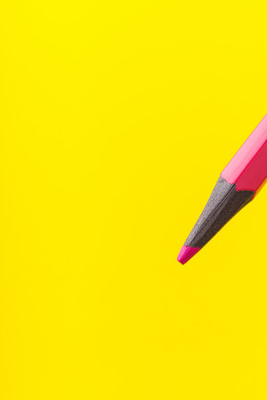 Colored pencil close-up with selective focus on the stylus and a blurred yellow background. Copy space for text.の写真素材