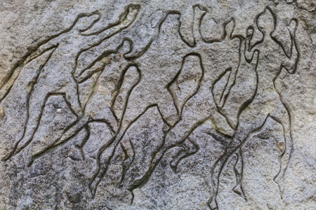 Ancient rock carvings in the form of primitive silhouettes of people. August 26, 2021 Chisinau Moldova, for illustrative editorial use. Background with copy space for textのeditorial素材