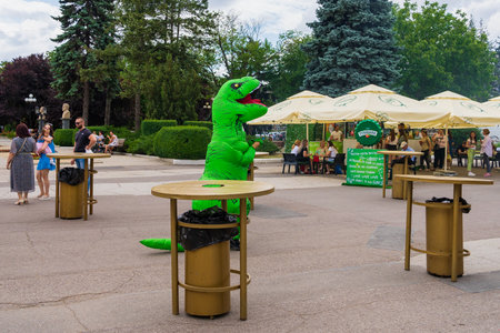 Animators at work at a street food festival. Dinosaur. Entertainment for tourists and citizens. June 25, 2022 Balti Moldova. Illustrative editorial.のeditorial素材