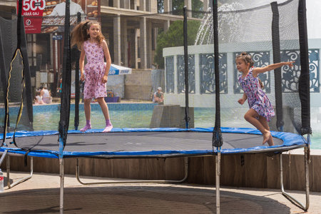 Happy children in the city are jumping on the trampoline. Area for children at a street festival. June 25, 2022 Balti Moldova. Illustrative editorialのeditorial素材