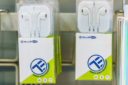 Headphones with a headset for a smartphone on a store shelf. Illustrative editorial. February 2,...