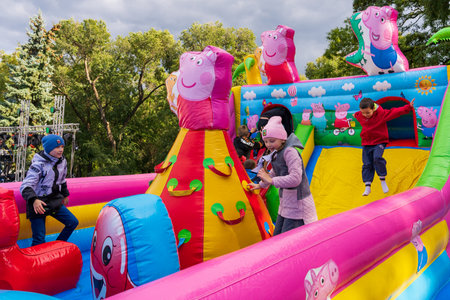 Children have fun on an inflatable slide in an urban environment at a city holiday. For editorial use. October 2, 2022 Balti Moldova.のeditorial素材