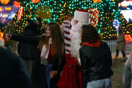 Background of a night Christmas town with people walking in the dark. December 28, 2021 Beltsy Moldova.のeditorial素材