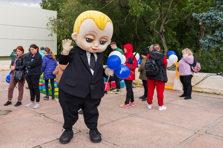 A man dressed in a huge doll of a schoolboy at a city holiday for children. For editorial use. October 2, 2022 Balti Moldova.のeditorial素材