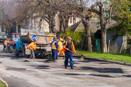 Road workers are repairing the road. Background with selective focus as copy space for text. October 25, 2022 Balti Moldova.のeditorial素材