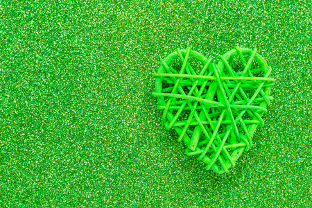 Wooden wicker heart. Rattan work in the shape of a heart. Love concept. Background with selective focus and copy space. Glitter backの写真素材
