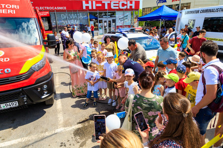 June 1, 2022 Balti Moldova. Illustrative editorial background. Firefighters show children how to operate a hydrant.のeditorial素材