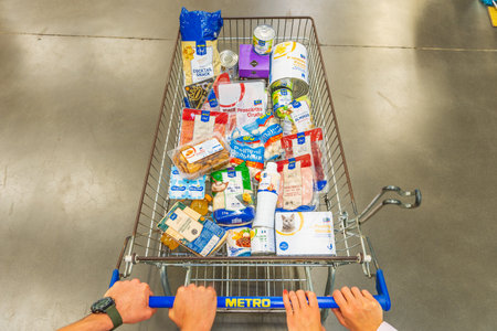 July 7, 2022 Beltsy, Moldova. For illustrative editorial use. Hands of a married couple on a food cart in a supermarket.のeditorial素材