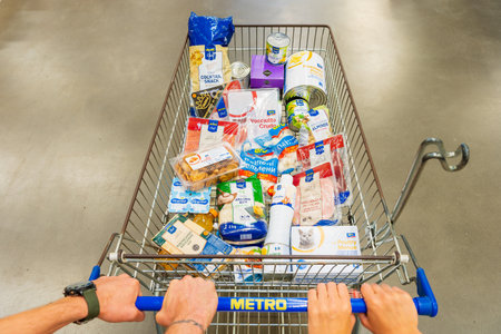 July 7, 2022 Beltsy, Moldova. For illustrative editorial use. Hands of a married couple on a food cart in a supermarket.のeditorial素材