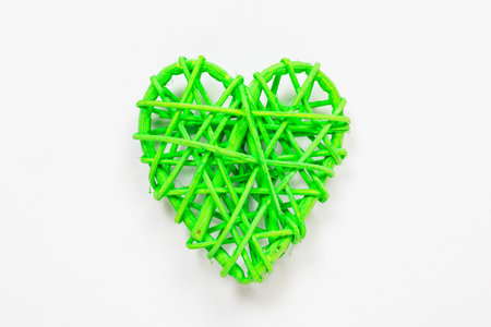 Wooden wicker heart. Rattan work in the shape of a heart. Love concept. Background with selective focus and copy space. Light backの写真素材