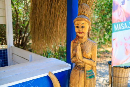 August 11, 2023 Oludeniz Turkey. For illustrative editorial use. Oriental wooden figurine of a praying woman. Place for a massage on the beachのeditorial素材