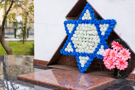May 6, 2023 Beltsy, Moldova. For illustrative editorial use. Flowers in the form of a six-pointed star at a memorial or monument to the Holocaust in memory of the Jewish victims of Nazismのeditorial素材