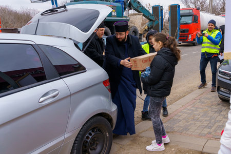 March 1, 2022 Sculeni Moldova. For illustrative editorial use. Volunteers at customs help refugees from Ukraineのeditorial素材