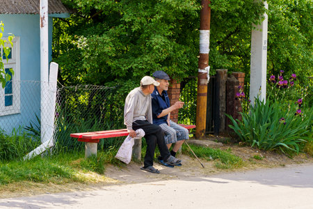 May 23, 2023 Dobruja village, Singerei district, Moldova. For illustrative editorial use. Villagers communicate while sitting on a benchのeditorial素材