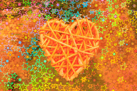 Wooden wicker heart. Rattan work in the shape of a heart. Love concept. Background with selective focus and copy space. Holographic backの写真素材