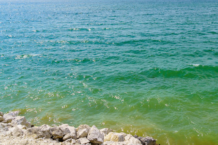 Rocky shore of a fresh reservoir. Background with selective focus and copy space for text.の写真素材