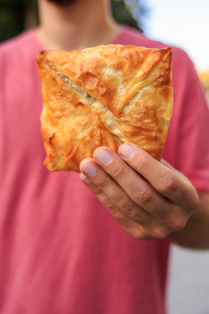 Vertical frame of hands holding pastries, fast food snack concept. Background with selective focus and copy space for textの写真素材