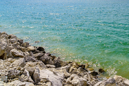 Rocky shore of a fresh reservoir. Background with selective focus and copy space for text.の写真素材