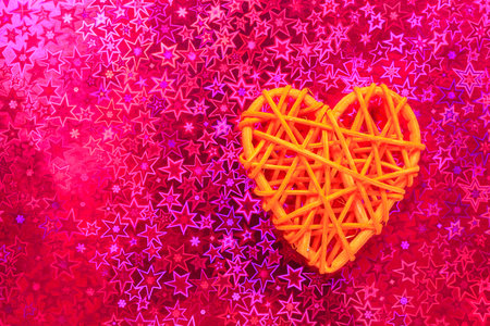 Wooden wicker heart. Rattan work in the shape of a heart. Love concept. Background with selective focus and copy space. Holographic backの写真素材