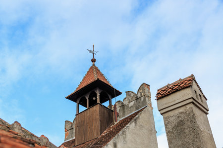 Historic european bell tower against blue sky with weather vane.の写真素材