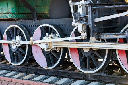 Vintage steam train wheels and gears in industrial setting.の写真素材