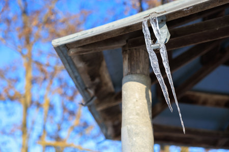 Icicles on the roof of the well. Background with selective focus and copy space for text
