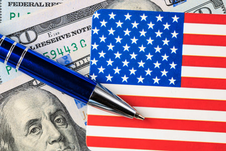 Us dollars with american flag and pen depicting financial patriotism.