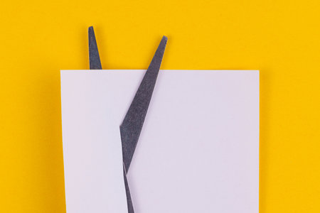 Stationery scissors cut paper. Background with selective focus and copy space for textの写真素材