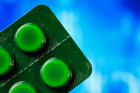 Close-up of green tablet blister pack against a vibrant blue background.