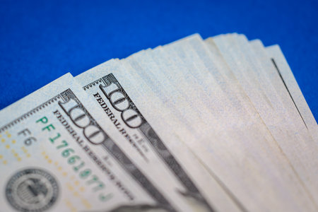 Close-up of 100 dollar bills on blue background.の写真素材