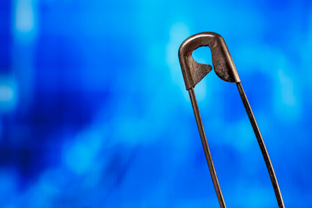 Close-up of safety pin against blue abstract background.の写真素材