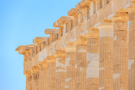 The building is made of stone and has a lot of columns. The columns are very tall and are spaced out evenly. The building has a very old and historic appearance, Acropolis in Athensの写真素材
