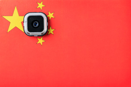 Security camera on chinese flag background symbolizing surveillance and technology.