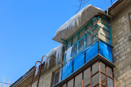 Large icicles on the roof pose a danger to passersby. Background with selective focus and copy space for textの写真素材