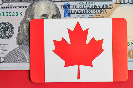 Canadian flag card on us dollar bill background: currency contrast and symbolism.の写真素材