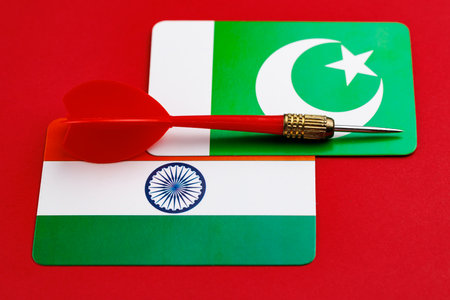 Red dart on indian and pakistani flags symbolizing tension or rivalry.の写真素材