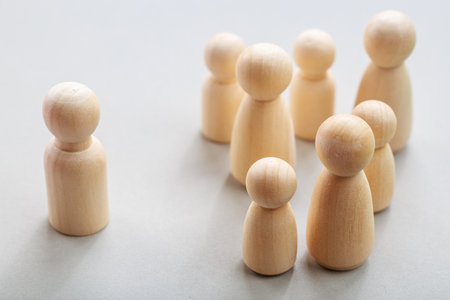 Wooden figures depicting social exclusion and group dynamics concept.の写真素材