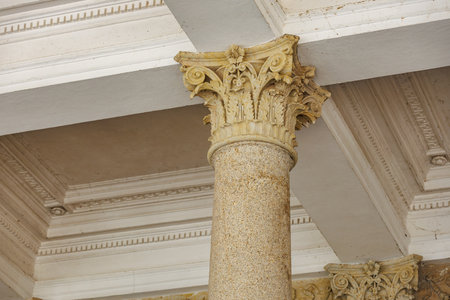 Ornate corinthian column in historic building with detailed architecture.