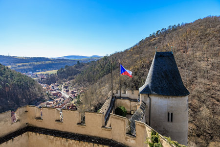 Scenic view of castle wall with czech flag and village in background.の写真素材