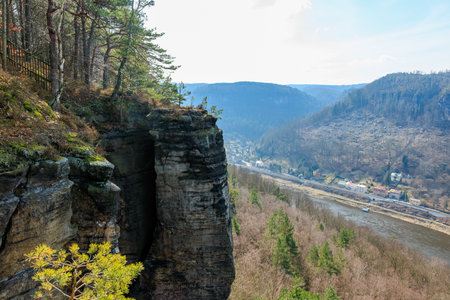 Scenic view of rocky cliff and river in mountains with forest in springtime.の写真素材