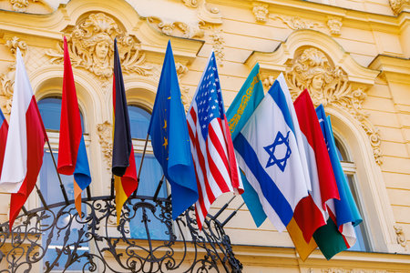 International flags displayed on historic building with european architecture.